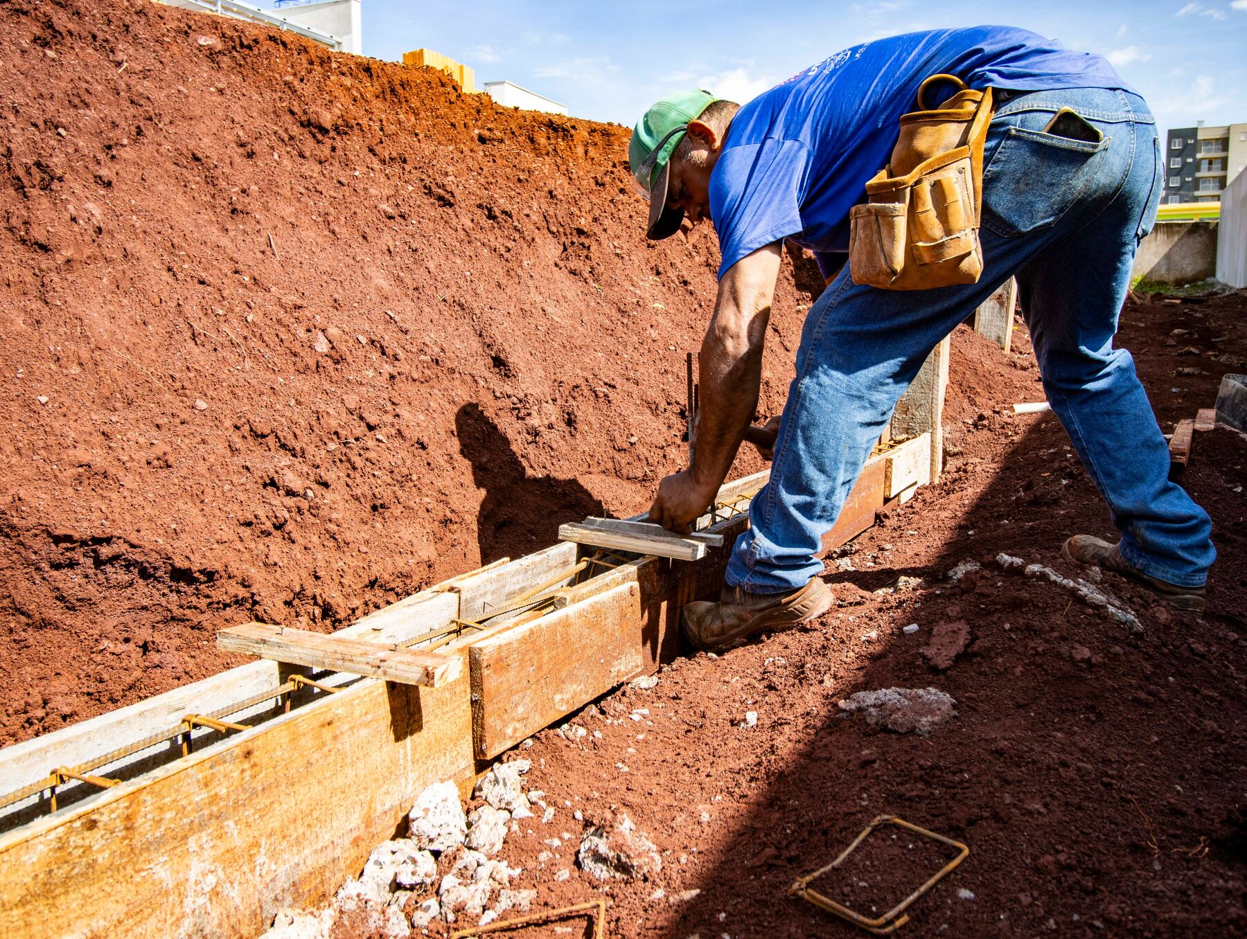Worker setting concrete formwork for a new foundation